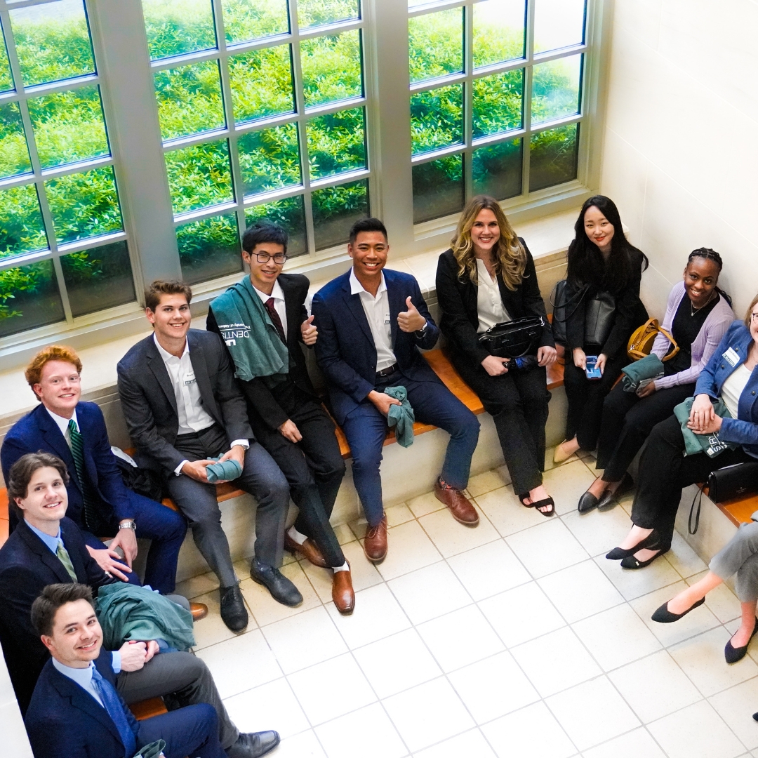 Group of people in business clothes sitting on a bench in an atrium